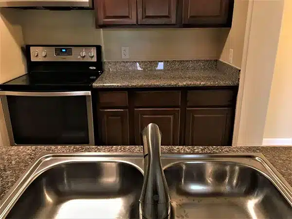 modern kitchen featuring a sleek stainless steel sink and stove, showcasing a clean and functional design.