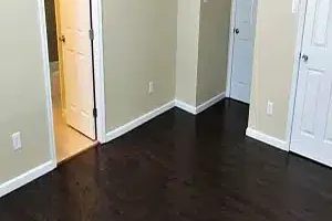 Room featuring hardwood floors and white doors.